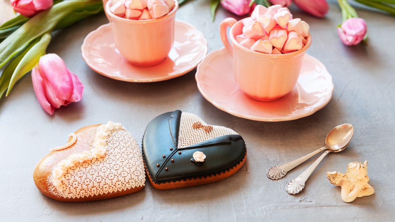 Две розовые чашки с маршмеллоу на сером фоне с печеньем и тюльпанами