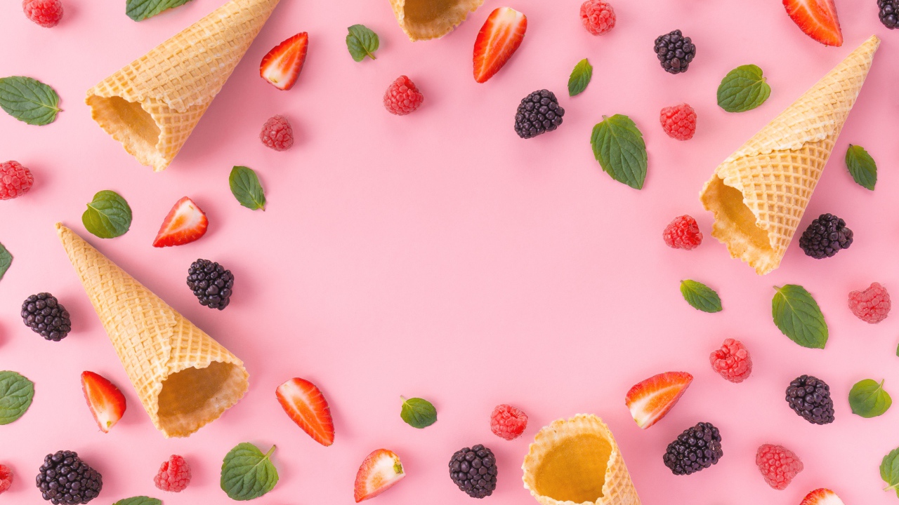 Вафельные рожки на розовом фоне с ягодами малины, клубники и ежевики
