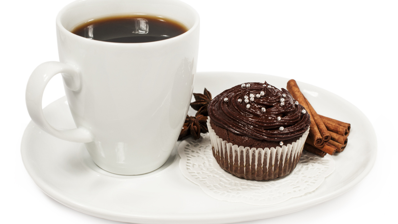 Чашка кофе на белой тарелке с кексом и корицей