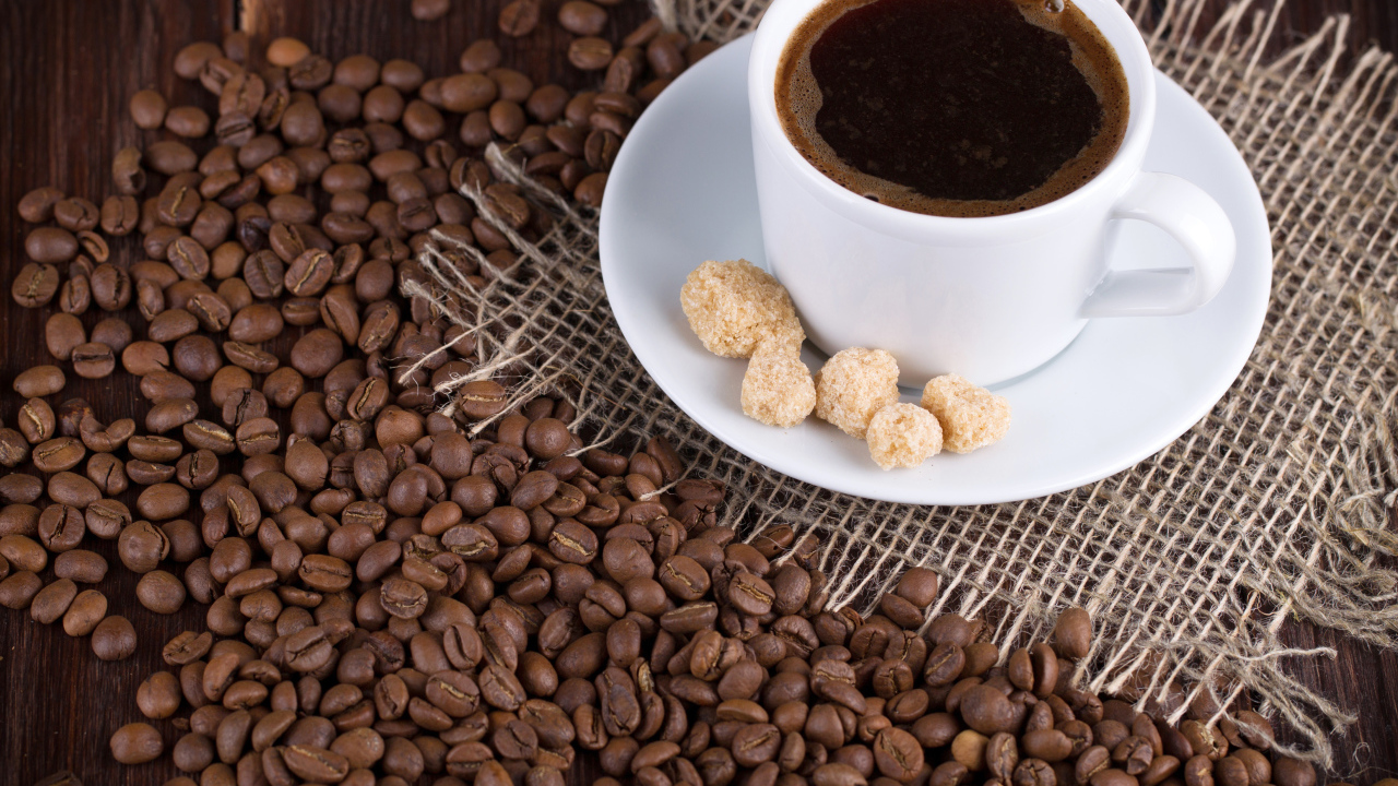 Чашка кофе с зернами на столе 