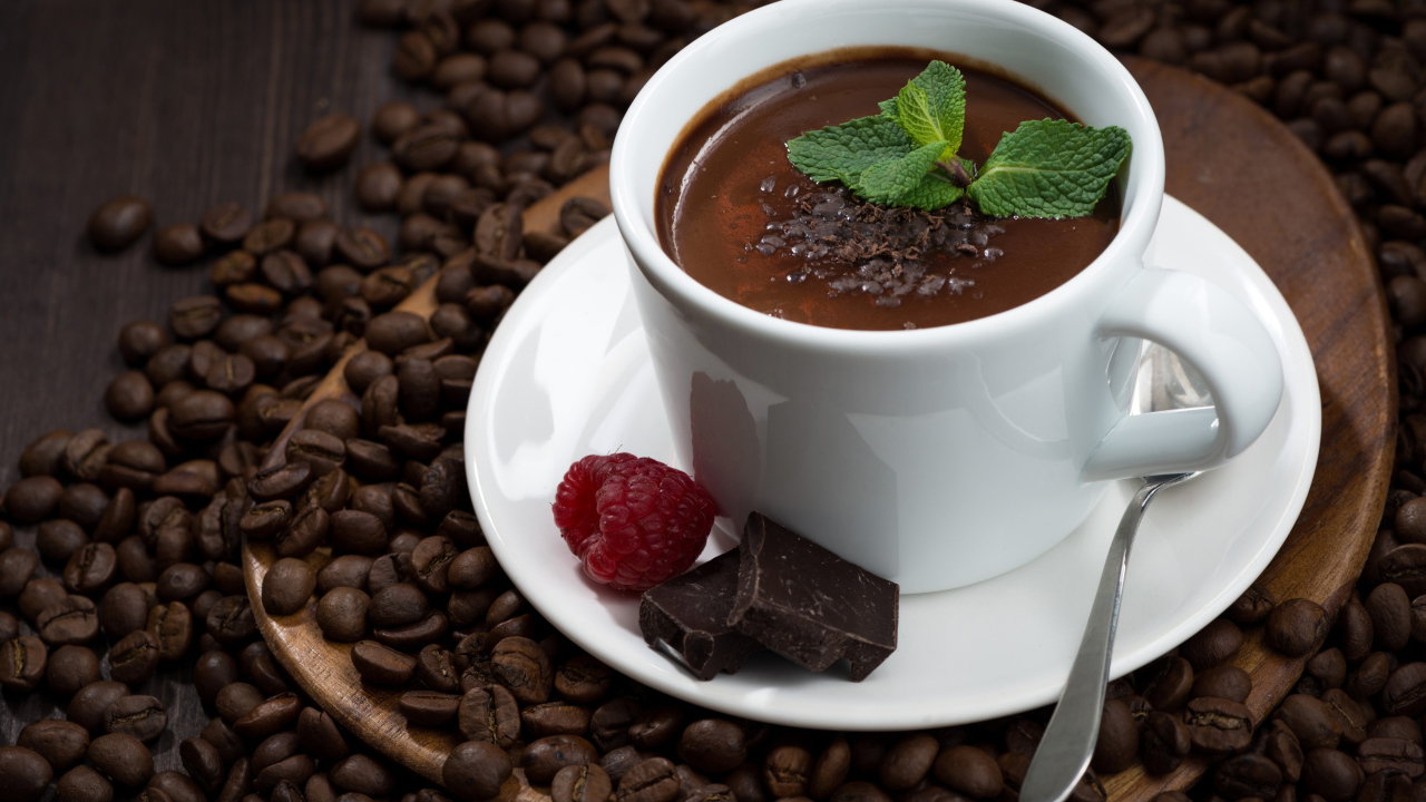 Чашка горячего шоколада на столе с кофейными зернами