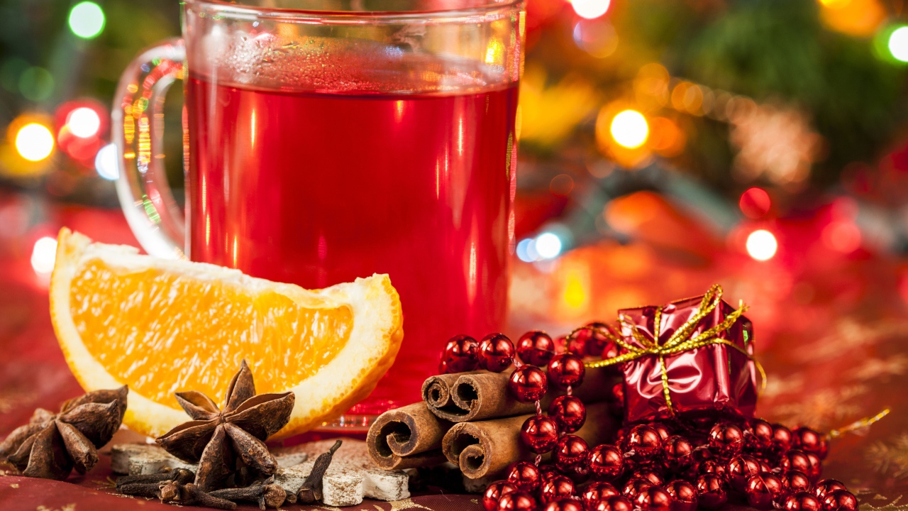 Чашка горячего чая на столе с корицей, бадьяном и кусочком апельсина 