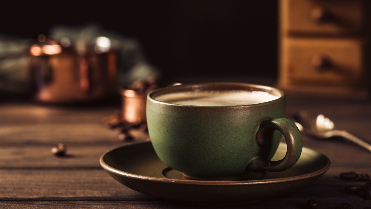 Большая чашка кофе на столе с кофейными зернами 