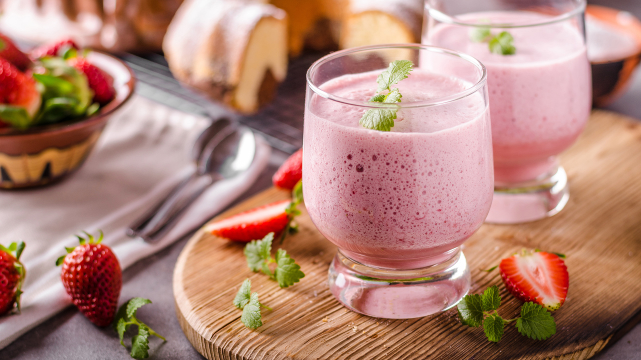 Ягодное смузи в стаканах на столе с клубникой