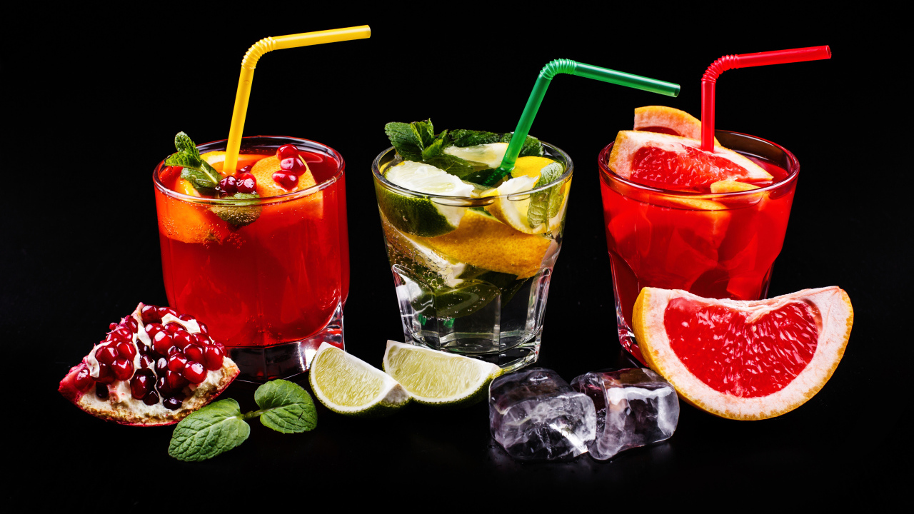 Цитрусовые алкогольные коктейли на черном фоне с фруктами