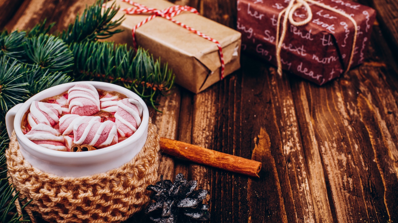 Чашка какао с маршмеллоу на столе с подарками