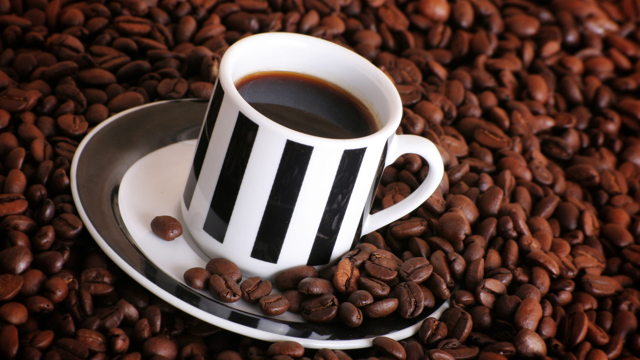 Чашка кофе на столе с кофейными зернами