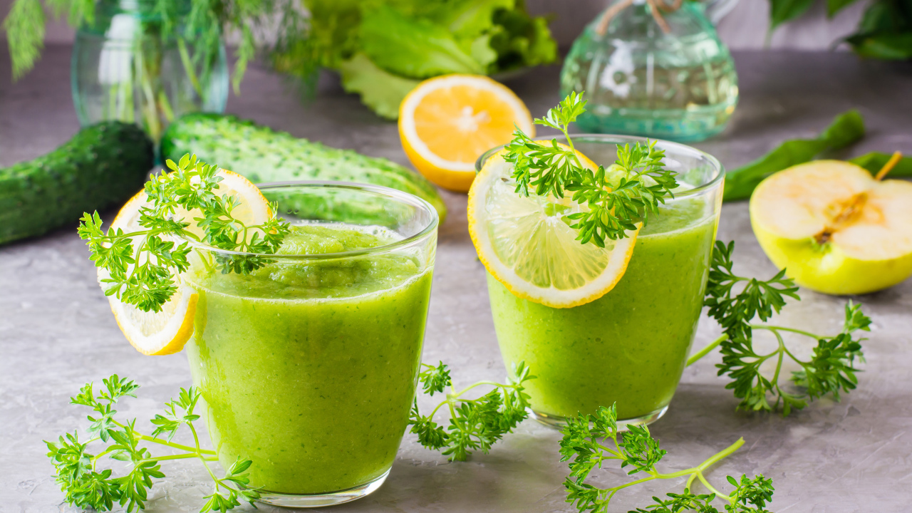 Зеленый смузи в стаканах с кусочками лимона и петрушкой
