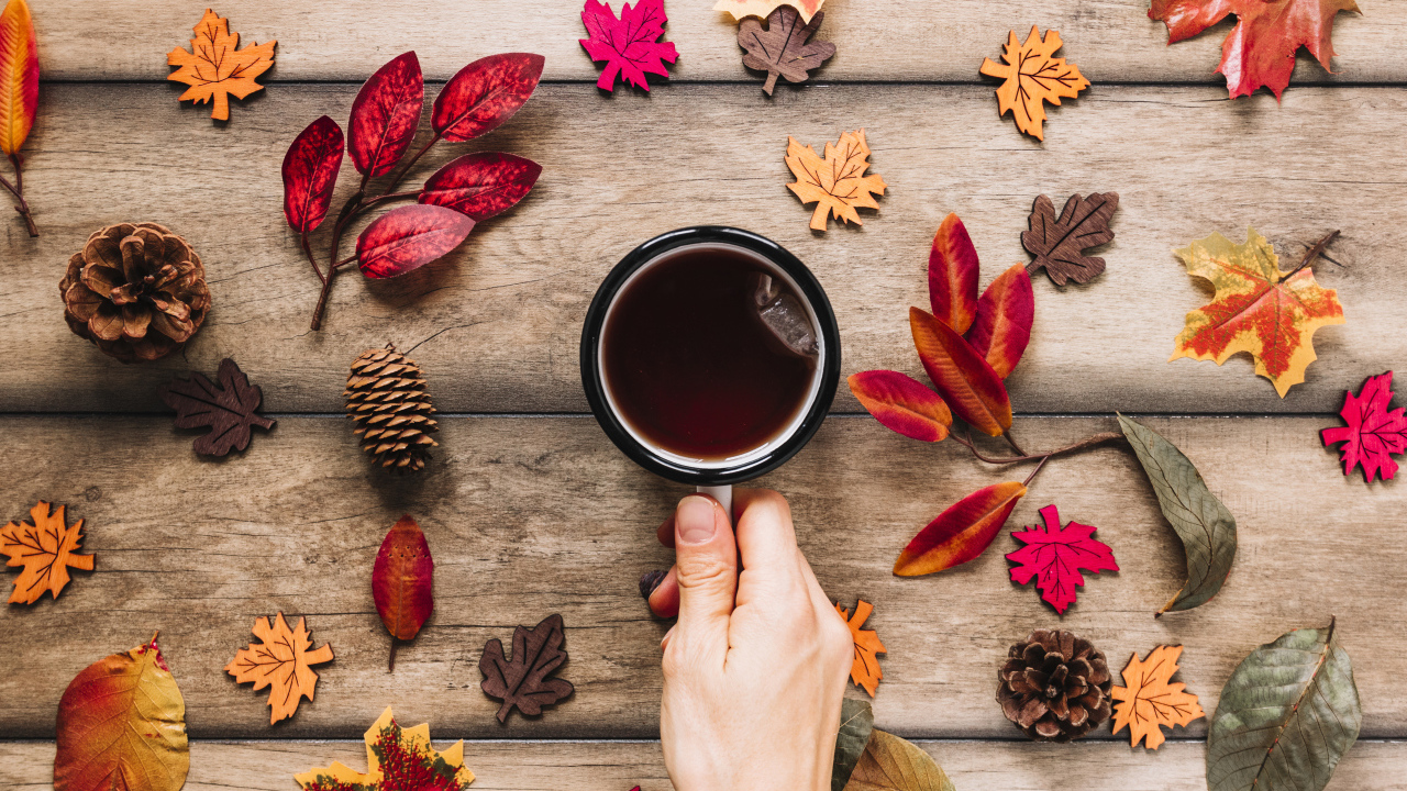Кружка чая на столе с осенними листьями