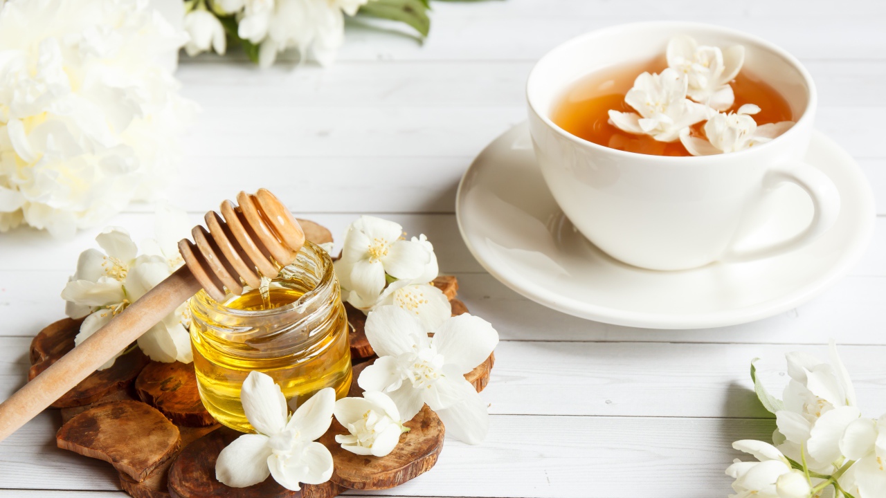 Чай на столе с медом и цветами жасмина