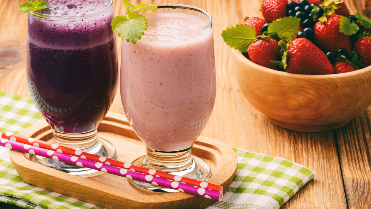 Два стакана смузи на столе с ягодами