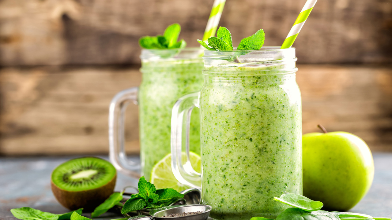 Два зеленых смузи на столе с киви, мятой и зеленым яблоком