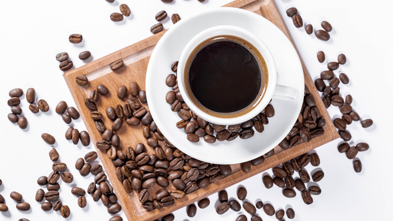 Белая чашка кофе на доске с кофейными зернами