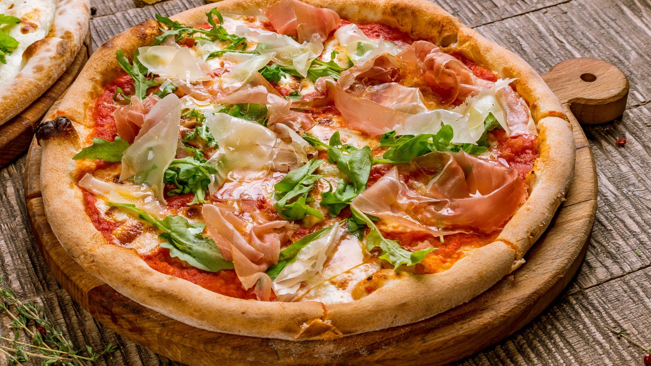 Пицца с рыбой и рукколой  на разделочной доске 