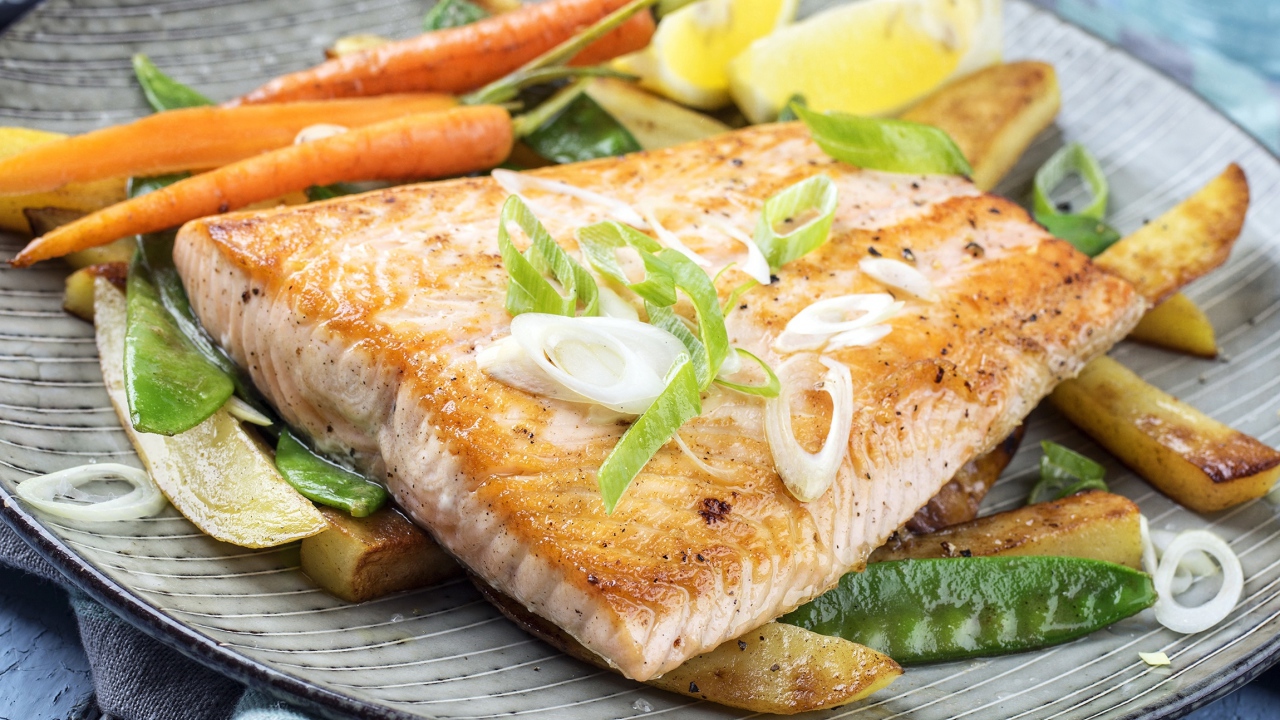 Запеченная красная рыба с овощами на тарелке