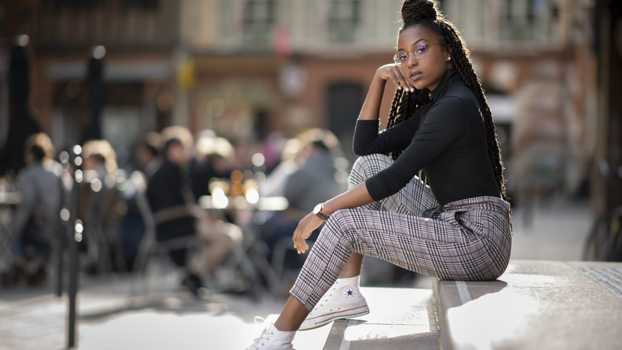 Красивая темнокожая девушка сидит на ступеньках