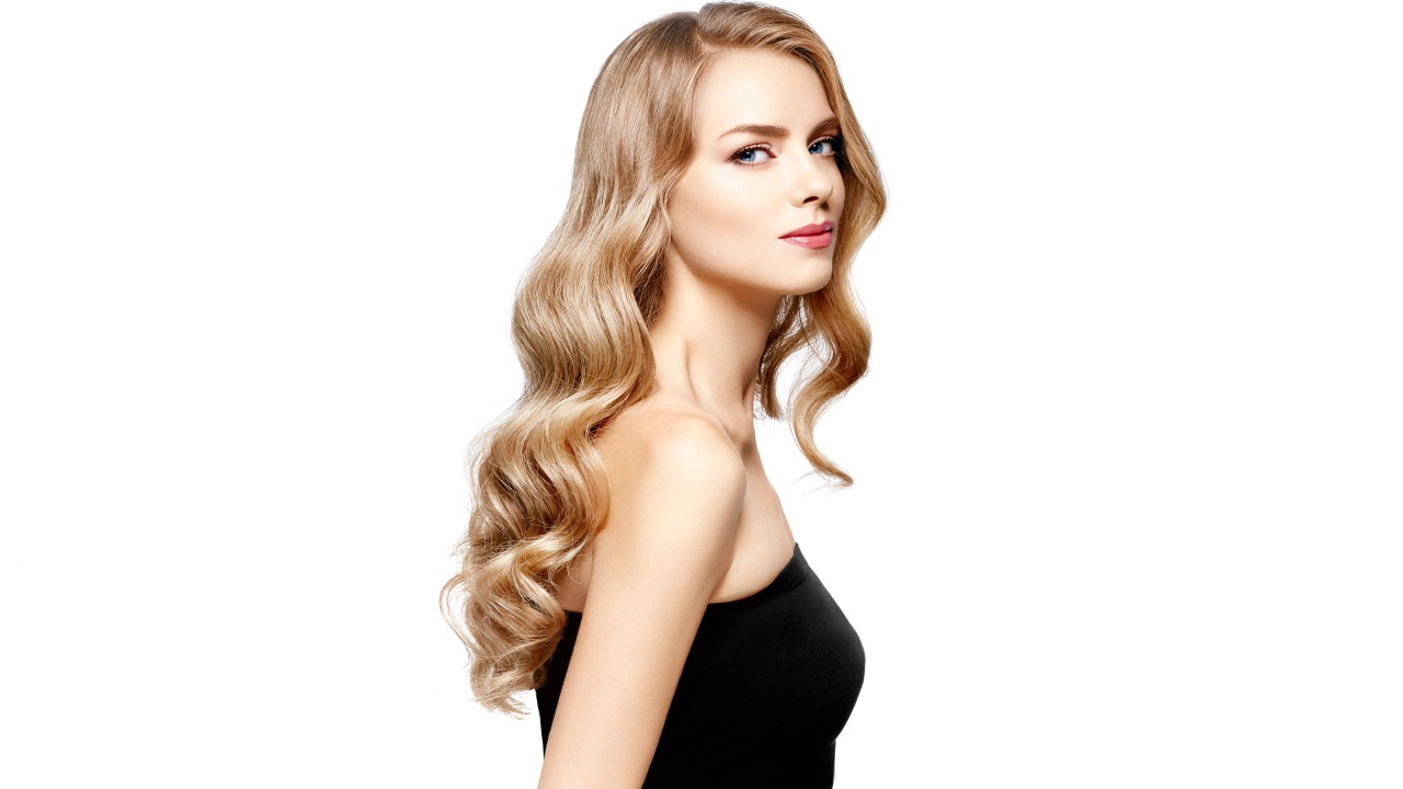 Красивая голубоглазая блондинка в черном наряде на белом фоне