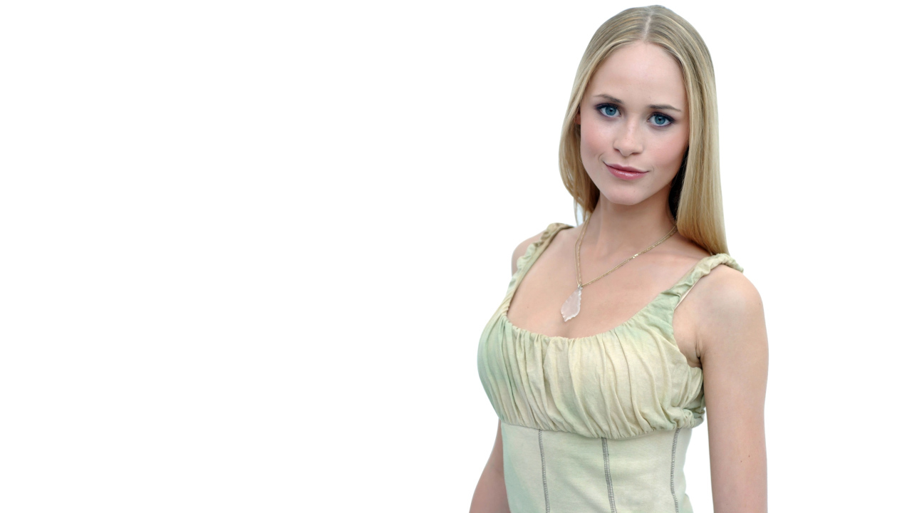 Красивая голубоглазая блондинка на белом фоне с кулоном на шее 