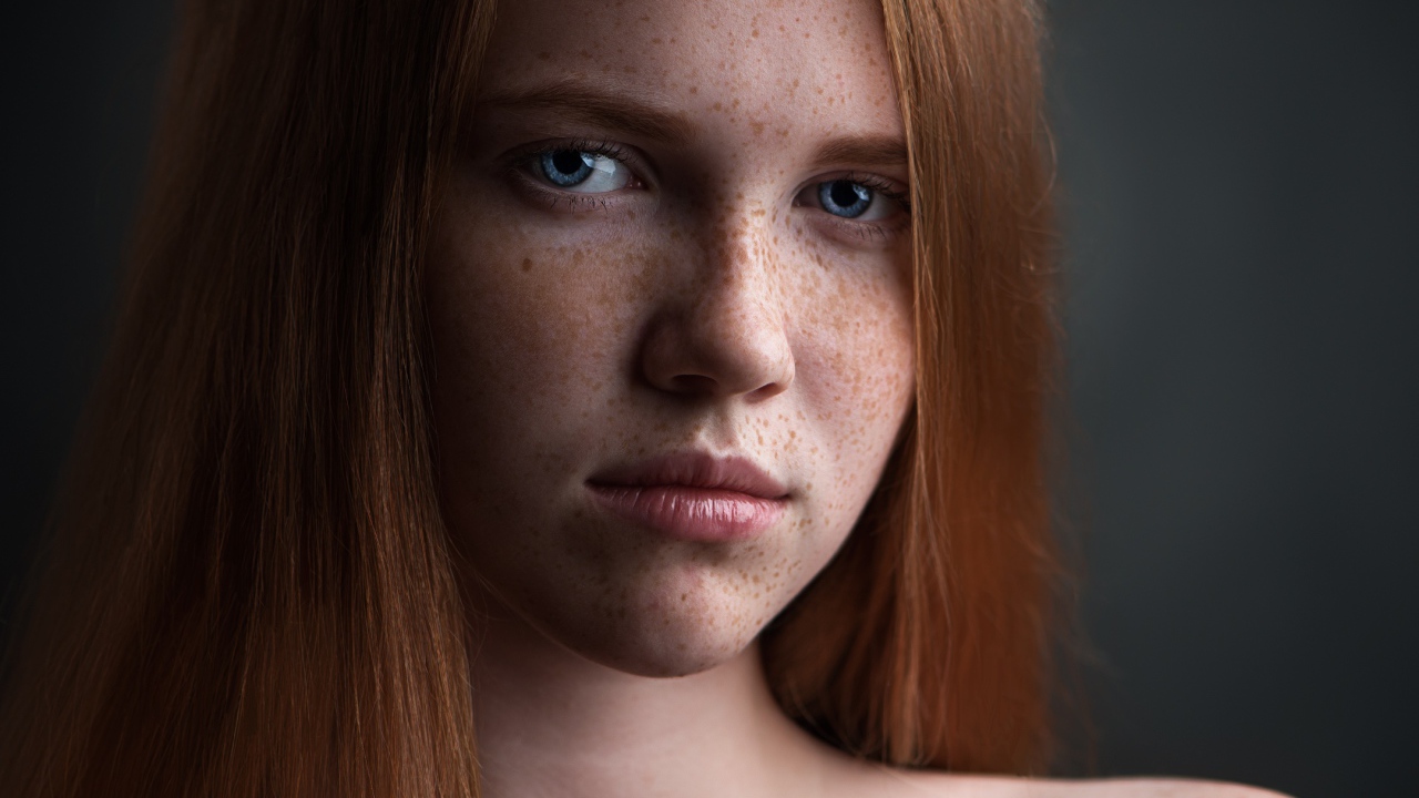 Красивая голубоглазая рыжеволосая девушка с веснушками