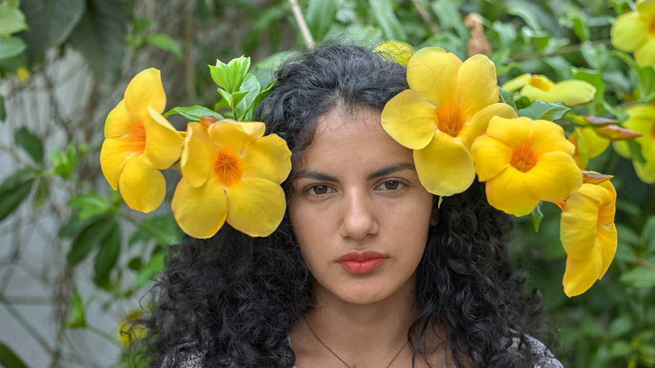 Красивая брюнетка с большими желтыми цветами в волосах 