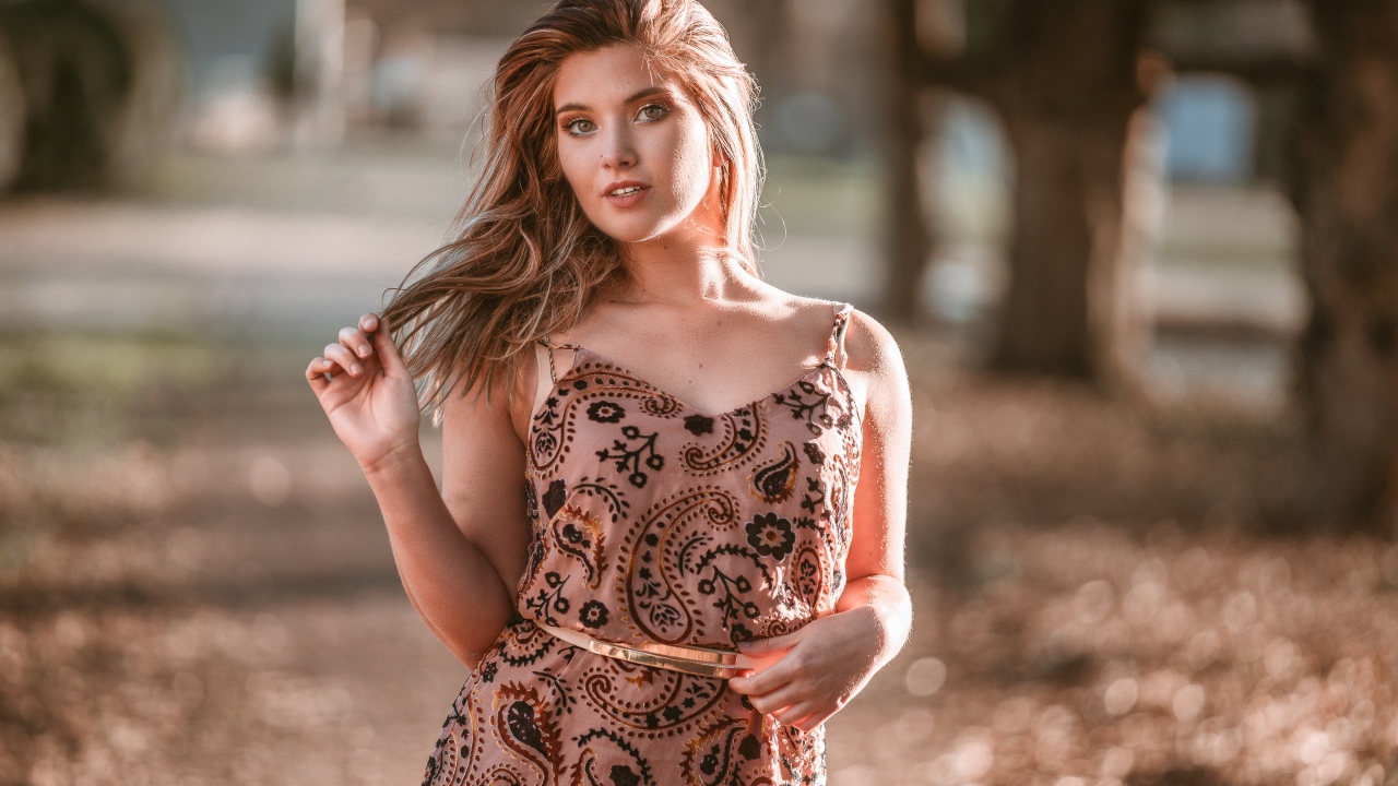 Красивая девушка в платье в лучах солнца летом