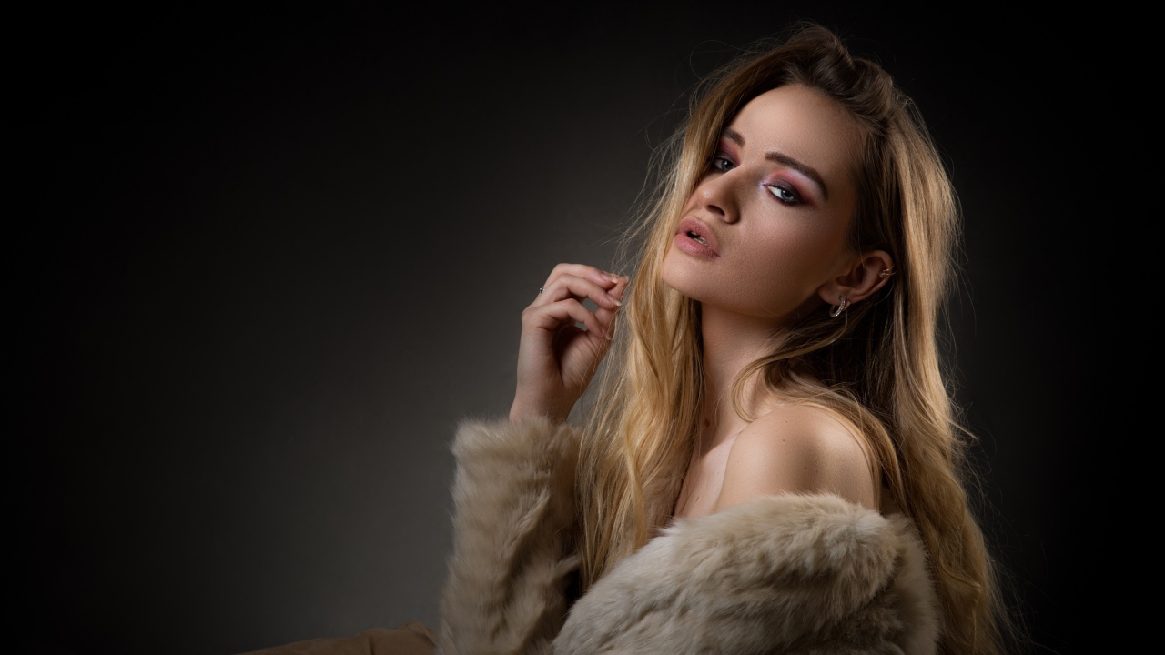 Красивая девушка в шубе на сером фоне