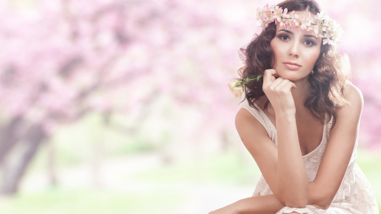 Красивая девушка в розовом платье с венком на голове