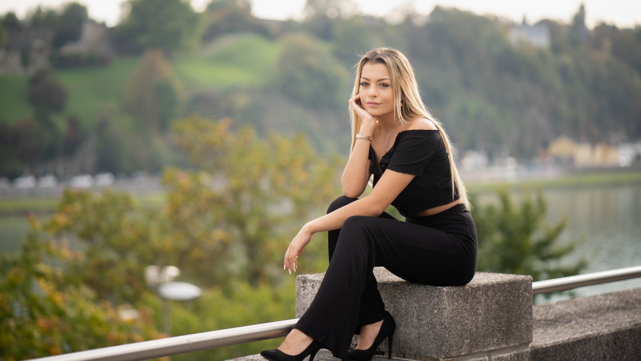 Красивая девушка в черном сидит