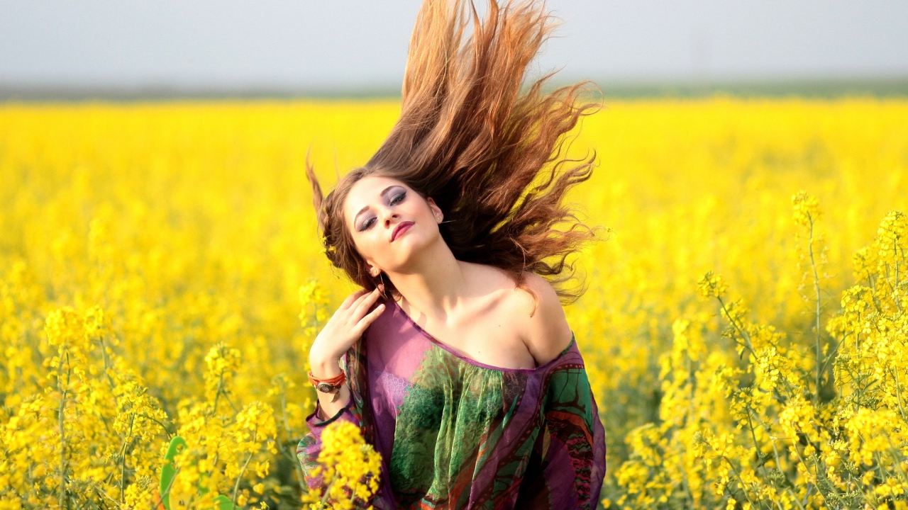 Красивая девушка на поле с желтыми цветами