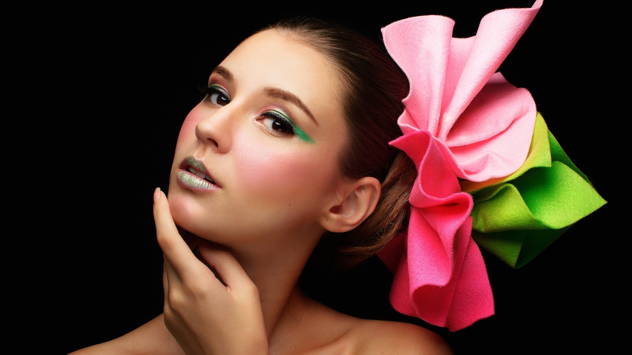 Красивая девушка с бантом в волосах на черном фоне