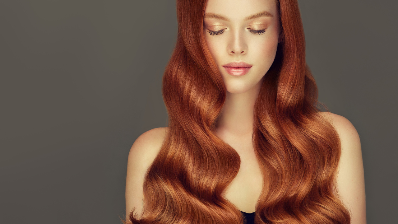 Красивая нежная рыжеволосая девушка на сером фоне