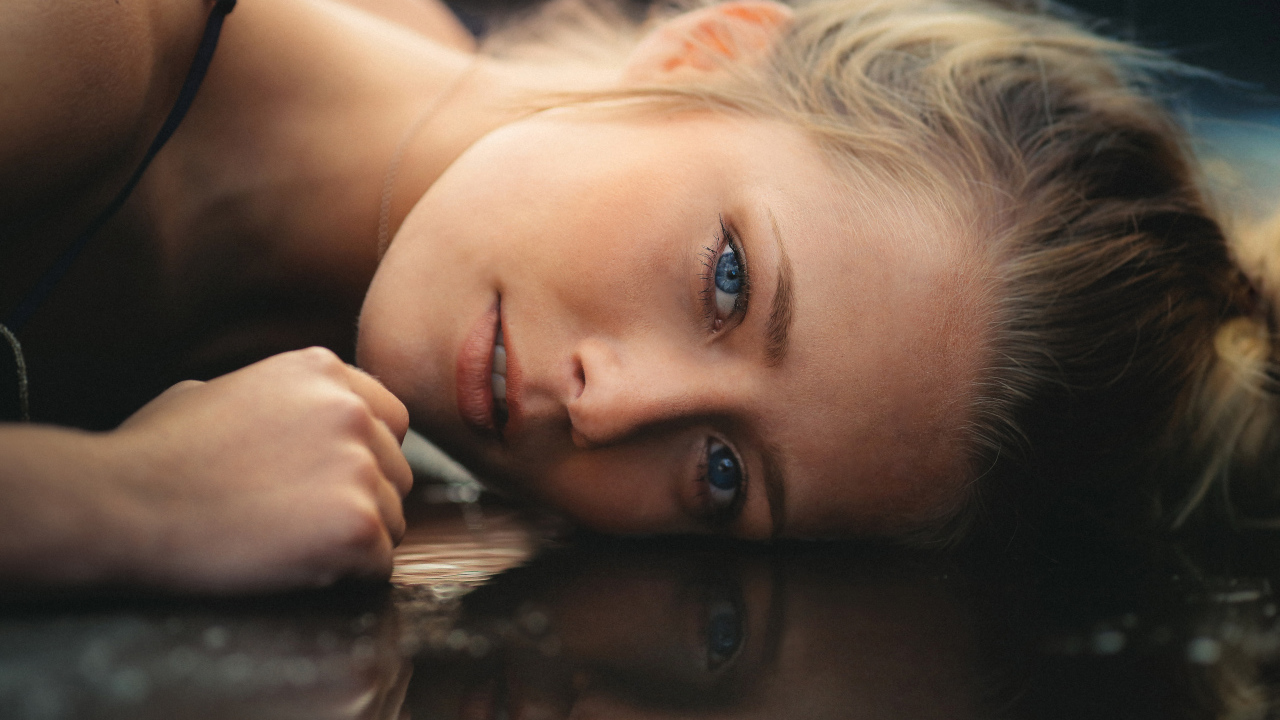 Голубоглазая девушка модель лежит на полу