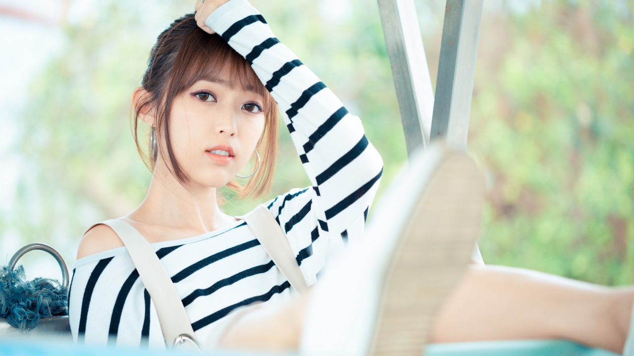 Кареглазая девушка азиатка в полосатом свитере