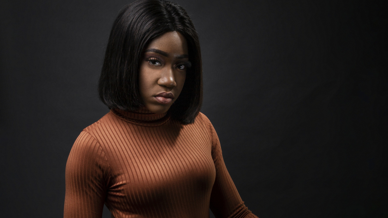 Темнокожая девушка с короткой стрижкой на сером фоне