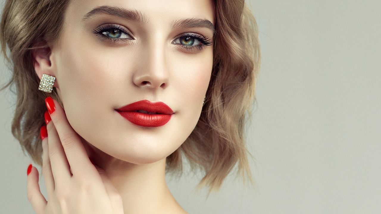 Лицо девушка с красивым макияжем на сером фоне