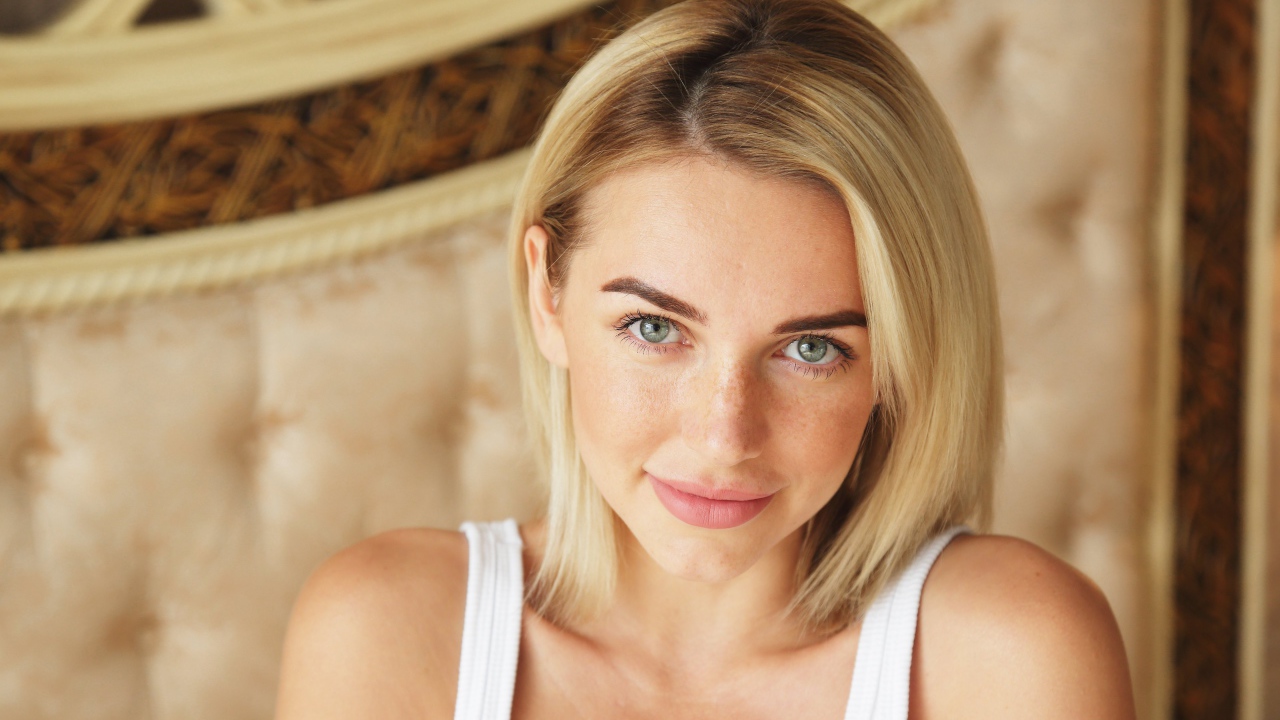 Нежная блондинка с зелеными глазами в белой майке