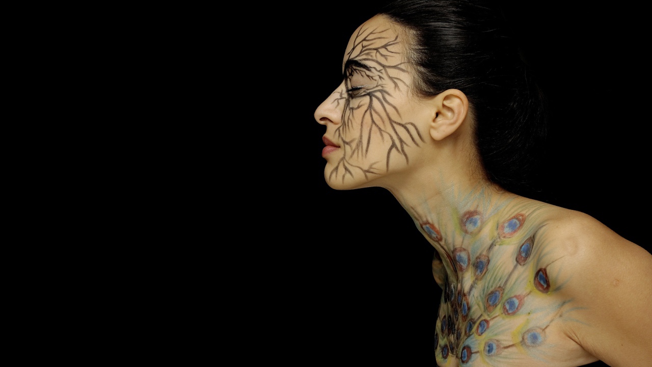 Девушка с рисунками на теле на черном фоне