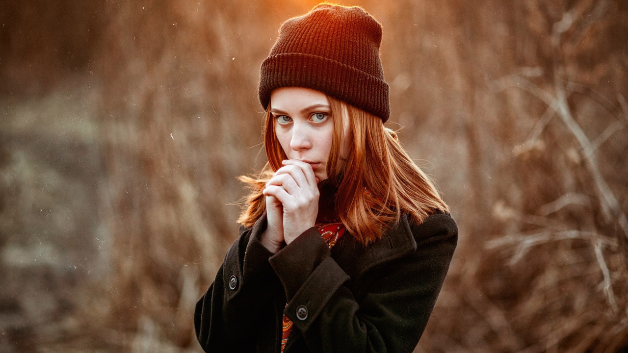 Рыжеволосая девушка в черной шапке в пальто 