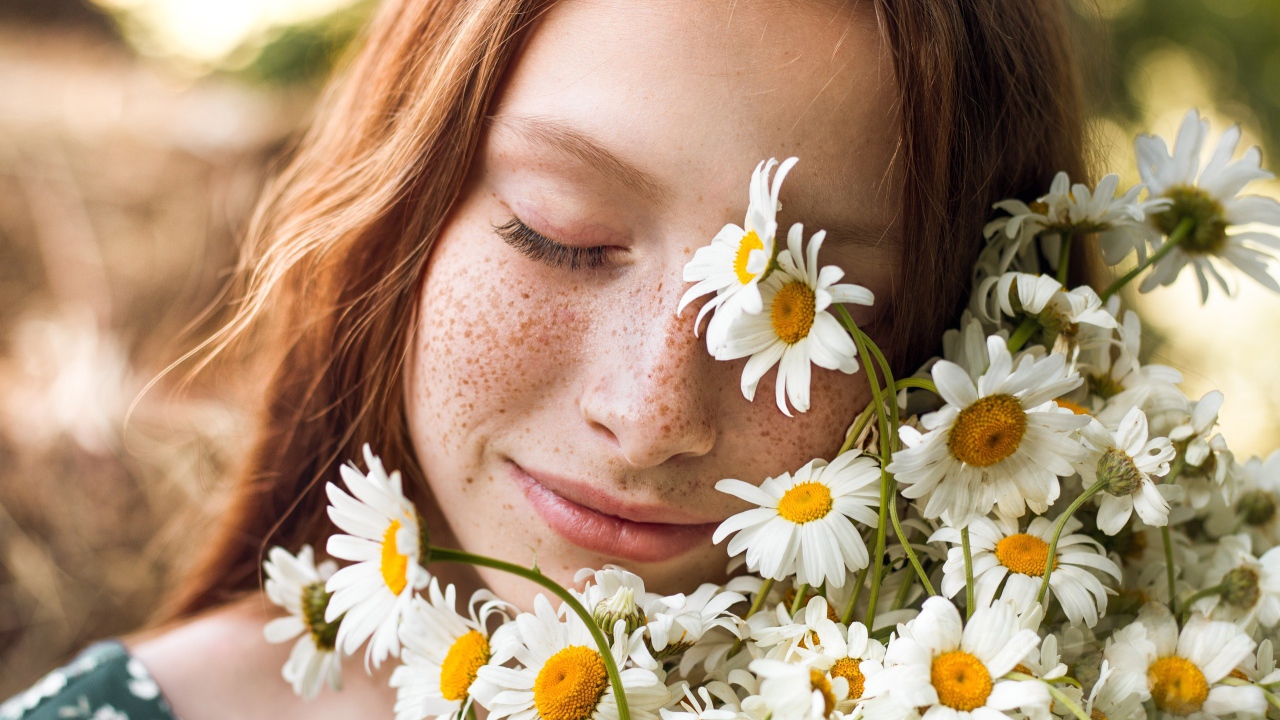 Рыжеволосая девушка с букетом ромашек