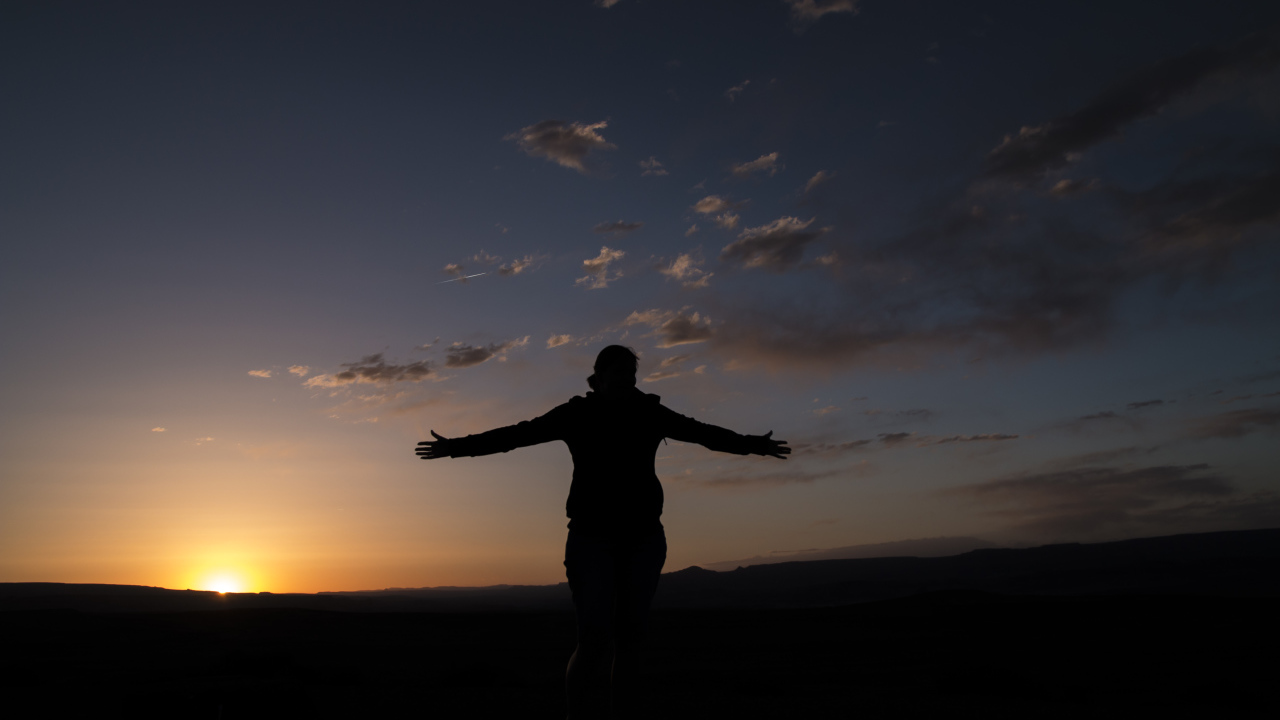 Силуэт девушки на фоне неба на закате