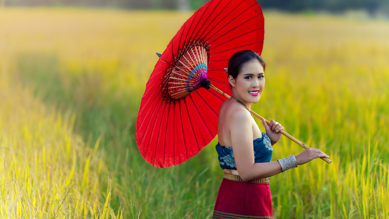 Улыбающаяся девушка азиатка с красным зонтом