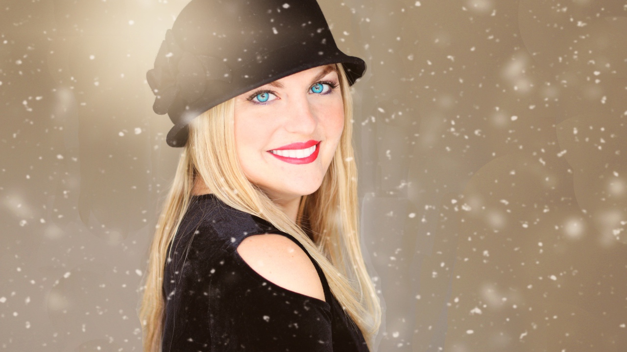 Улыбающаяся голубоглазая девушка в черной шляпе
