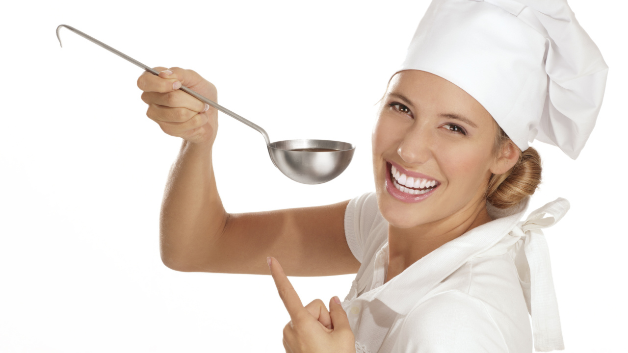 Улыбающаяся девушка в костюме повара с половником