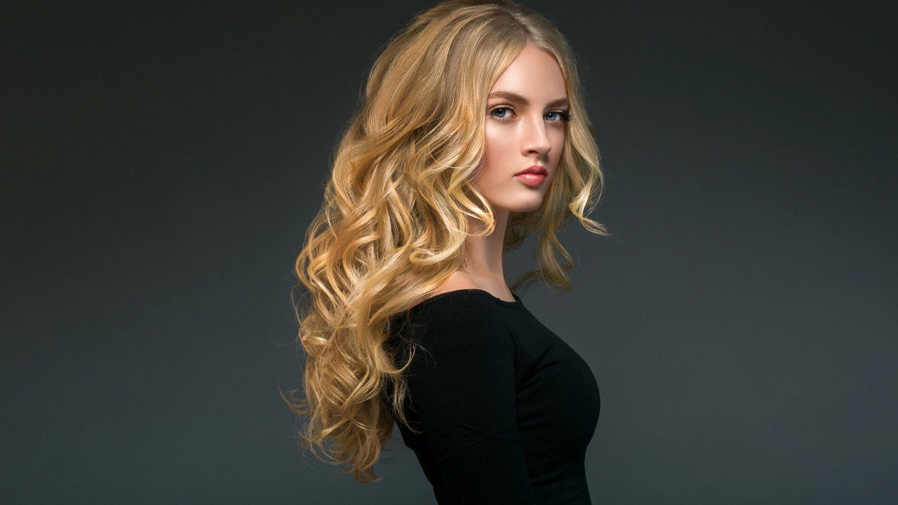 Стильная голубоглазая длинноволосая девушка в черном наряде