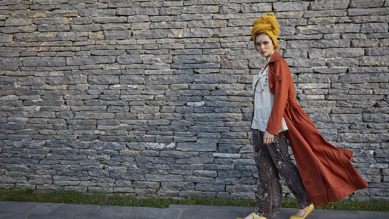 Стильная девушка на фоне стены 