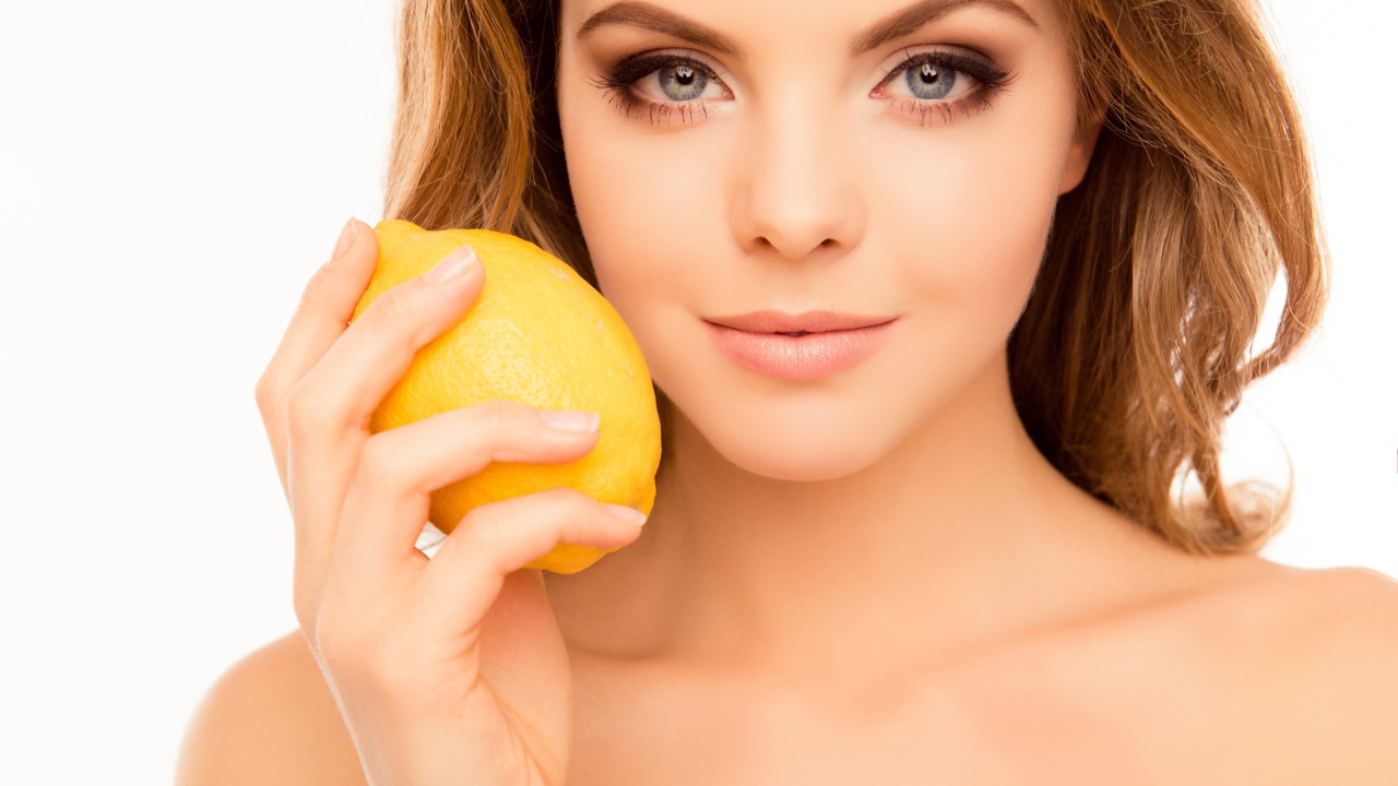 Нежная голубоглазая девушка с лимоном в руке