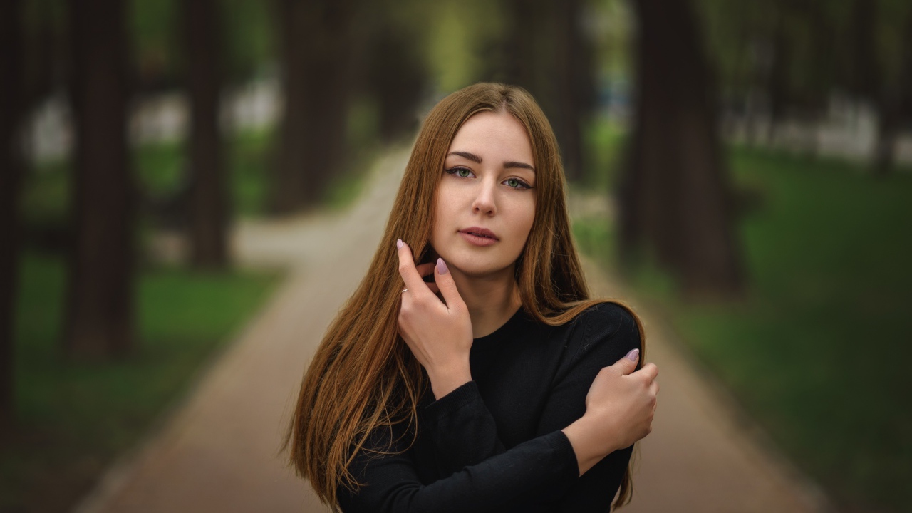 Молодая девушка в черном наряде в парке