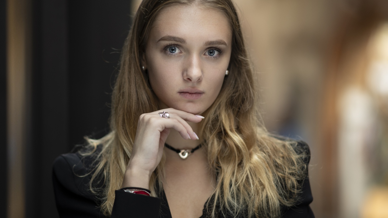 Молодая нежная голубоглазая девушка с рукой у лица