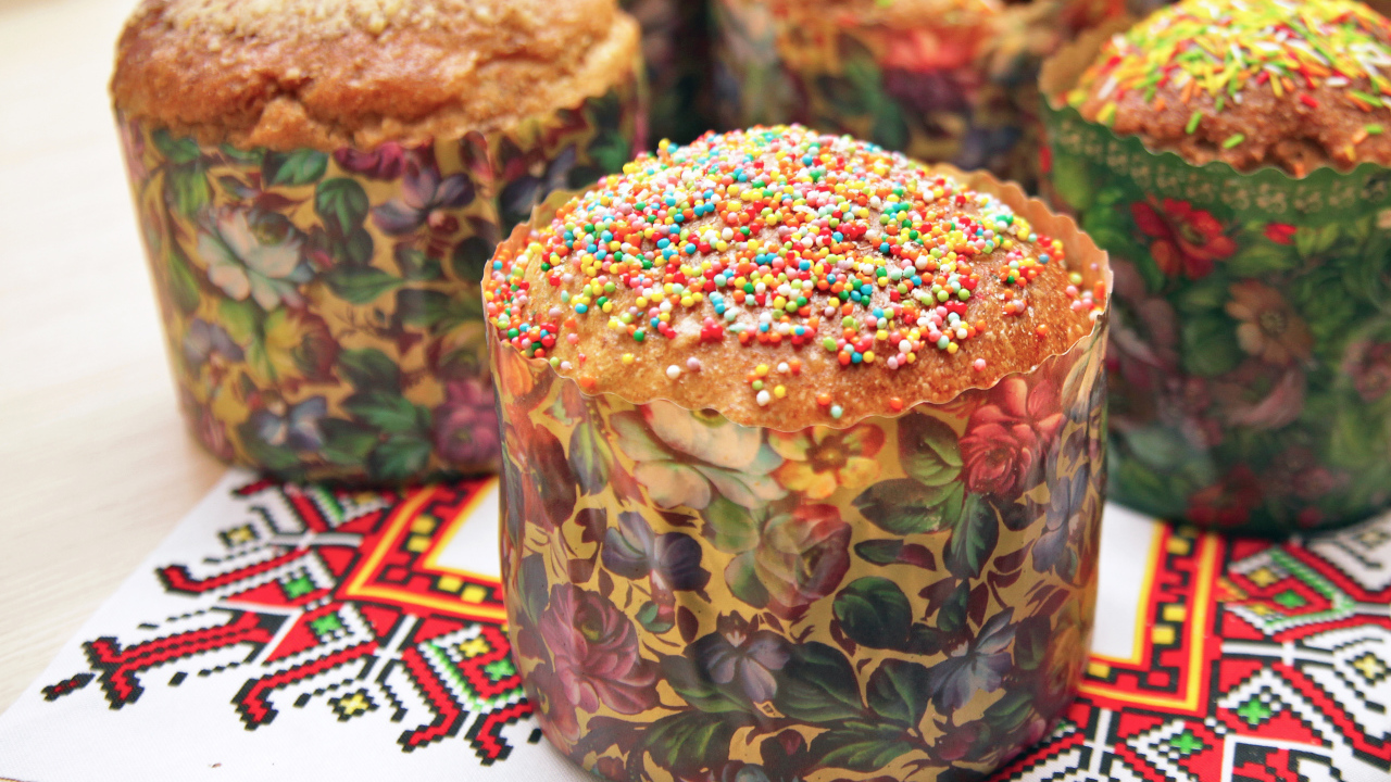 Вкусные сладкие куличи с посыпкой стоят на рушнике