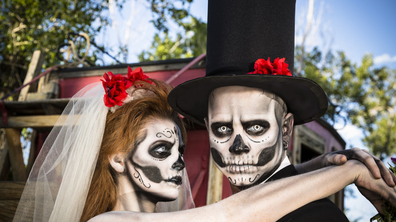 Пара жених и невеста с масками с грима на лице на Хэллоуин 